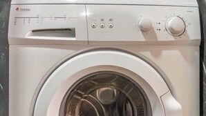 Máquina de lavar roupa branca com painel de comandos, visor digital e porta frontal.