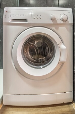 Eine weiße Waschmaschine mit Bedienfeld, digitalem Display und einer Frontöffnung.