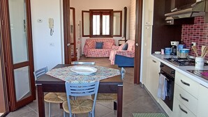 A compact kitchen with a dining area, a built-in oven, and a small window. - Villa Cloe: For Those Who Love Peace and Quiet (San Vito Lo Capo)
