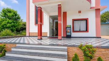 Un edificio moderno con suelo a cuadros, una escalera que conduce a la entrada y una puerta de vidrio.