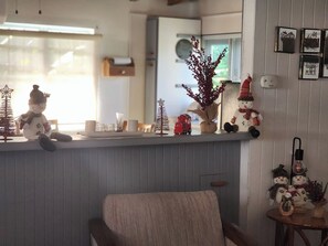 A kitchen area with a wooden countertop, a chair, and various Christmas decorations including a snowman and a small tree. - Casa Isabel en Calvache Rincon PR for 6 people. (Rincon)