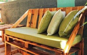 A wooden bench with a green cushion and a checkered pillow. - Casa Isabel en Calvache Rincon PR for 6 people. (Rincon)