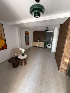 A modern interior with a dining area, a sofa, and a coffee table with flowers. - Modern business studio in central Larnaca - AC, WiFi, elevator (Larnaka)