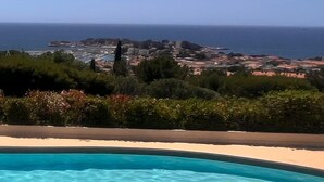 Una piscina amb vistes al mar i una vila de fons.