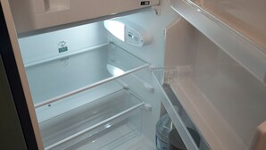 Et tomt køleskab med vanddispenser og kontrolpanel.