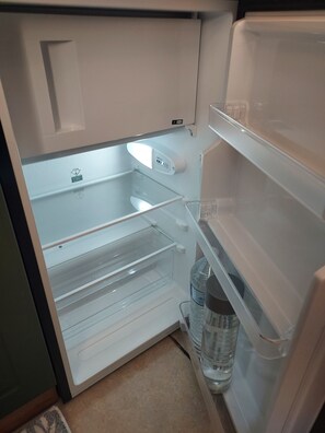 Ein leerer Kühlschrank mit Wasserspender und Bedienfeld.