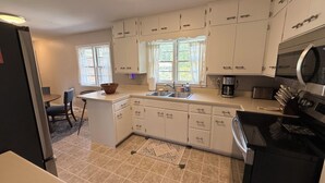 A compact kitchen with white cabinets, a built-in oven, and a coffee maker. - The Brick Haven in Brookings - spacious home in a central location! (Brookings)