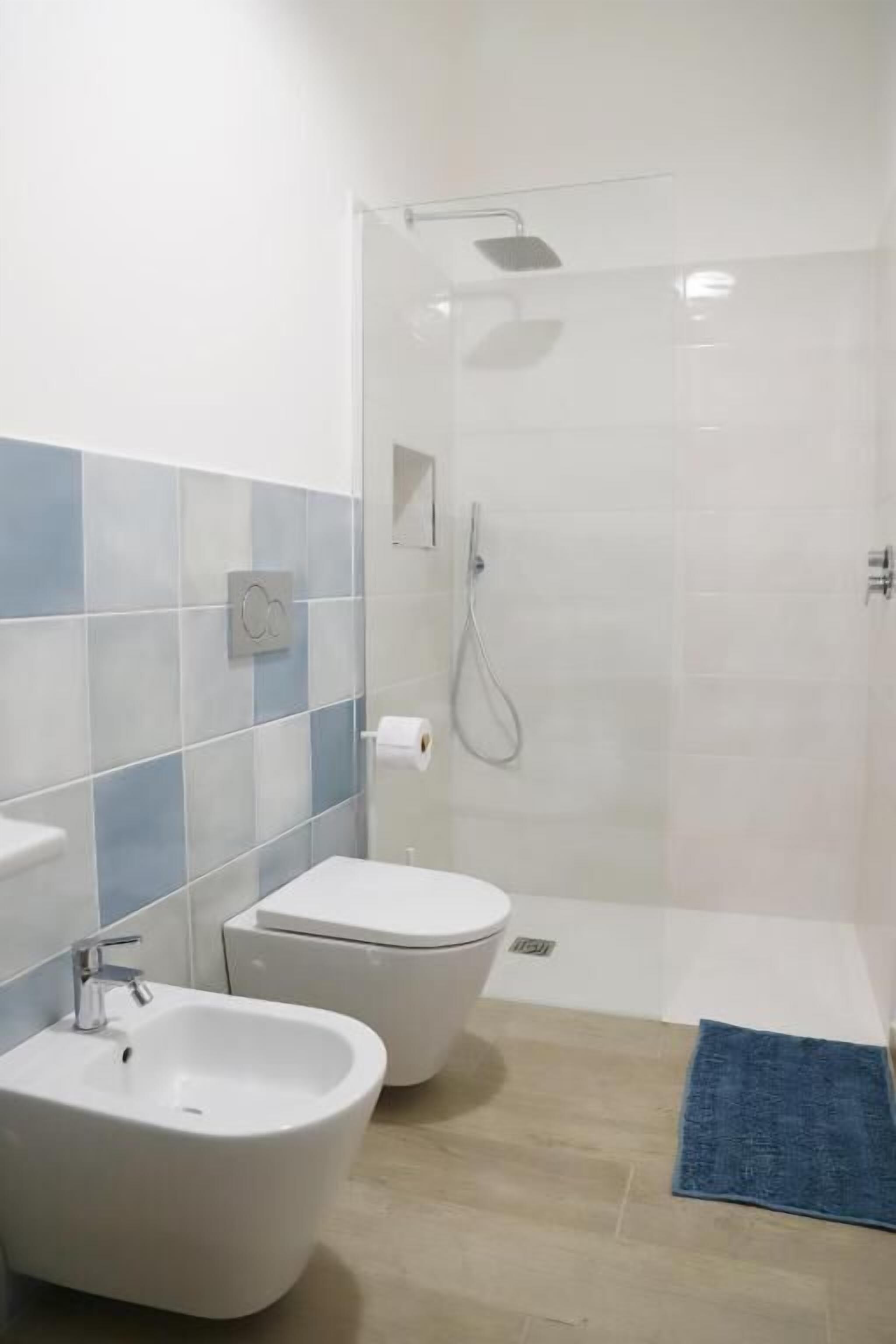 Un baño con ducha, bidé e inodoro.
