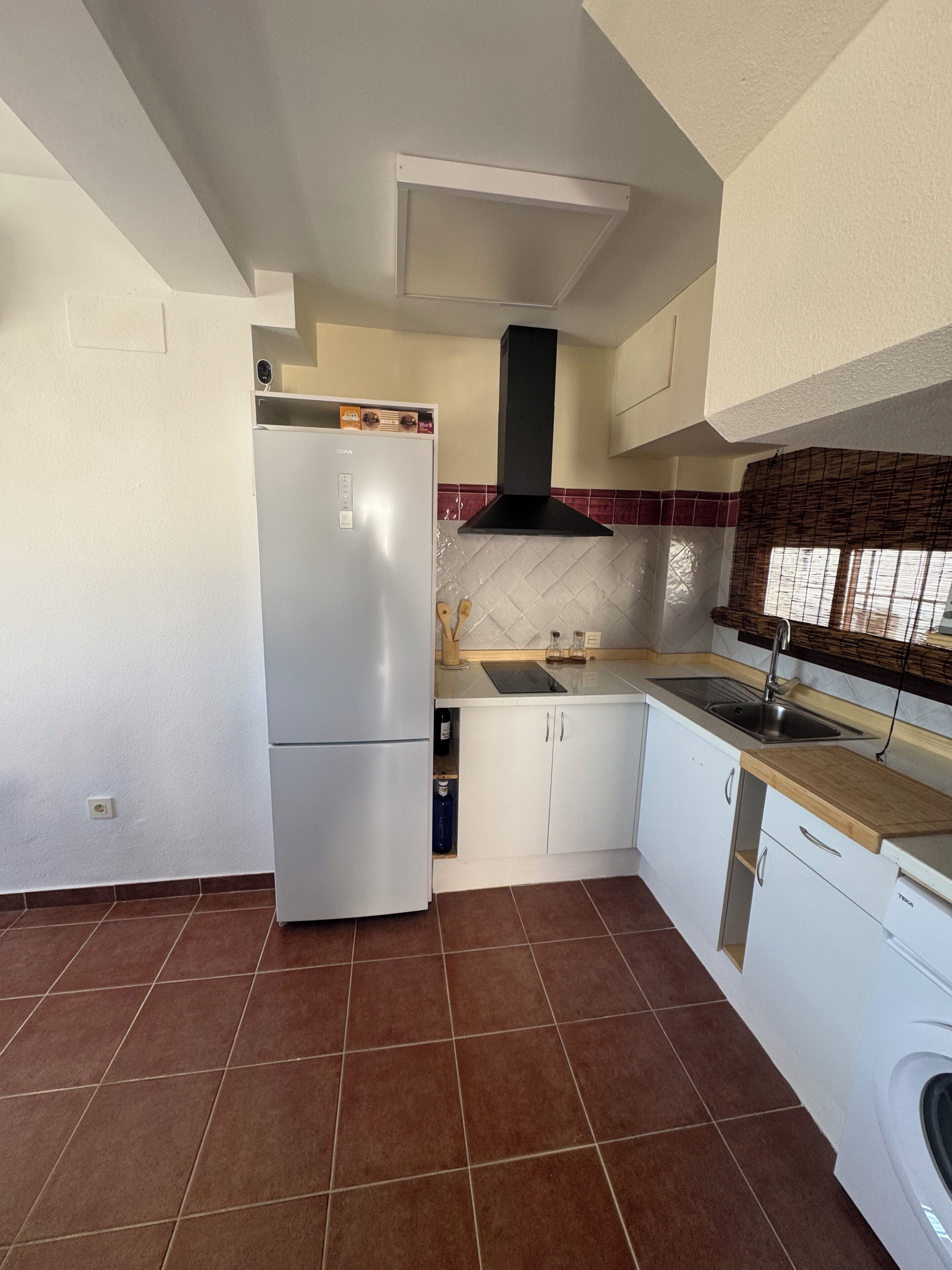 A kitchen with a white refrigerator, a stove, a sink, and a dishwasher.
