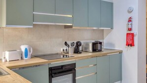 Eine moderne Küche mit integriertem Mikrowellenherd, Toaster und Wasserkocher auf der Arbeitsfläche.