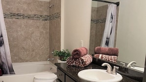Une salle de bain avec une baignoire, des toilettes, un lavabo et un miroir.