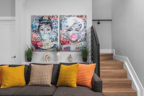 A modern living room with a grey sofa, colorful cushions, and two large abstract paintings on the wall. - LUXE 4BR Pool Oasis Near Wynwood & Design District (Miami)