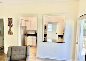 A modern kitchen with white cabinets, a stainless steel refrigerator, and a black countertop.