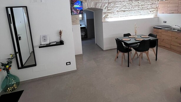 Een modern interieur met een eetgedeelte, keuken en een vide met onbehandelde bakstenen muren.