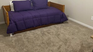 A bedroom with a bed, a wall with a 'love' sign, and a wreath. - Family Fun Meets Cozy Comfort - 3 Bedrooms, 2 Bathrooms, Game Room and Hot Tub! (Odessa)