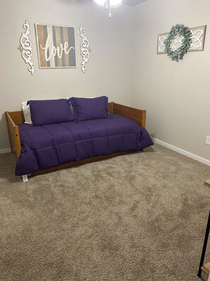A bedroom with a bed, a wall with a 'love' sign, and a wreath. - Family Fun Meets Cozy Comfort - 3 Bedrooms, 2 Bathrooms, Game Room and Hot Tub! (Odessa)