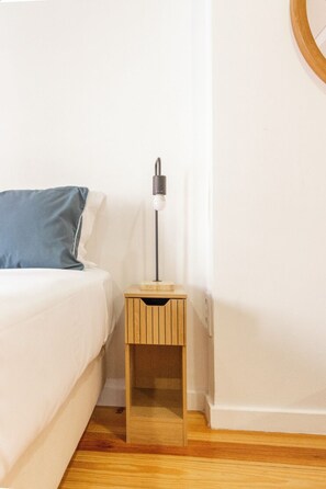 A bedroom with a bed, a bedside table with a lamp, and a wooden nightstand. - Bairro Alto Studio 2 · Right in the Heart of the City · AC (Lisboa)