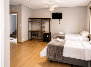 Un dormitorio con dos camas, un escritorio y una televisión.