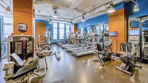 Ein Fitnessraum mit verschiedenen Trainingsgeräten, darunter Laufbänder und Kraftgeräte.