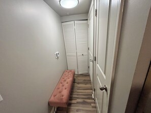 A narrow hallway with a bench, a door with a handle, and a light fixture on the ceiling. - Exceptional Location - Downtown DC, Walk to Shops, Rooftop Pool, Jacuzzi, Gym (Washington)