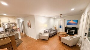 Un salon moderne avec un canapé, une table basse et un téléviseur.