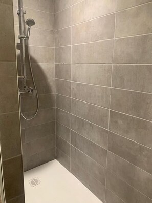 A shower area with a handheld showerhead and a wall-mounted control. - New home in St. Siffret (Saint-Siffret)