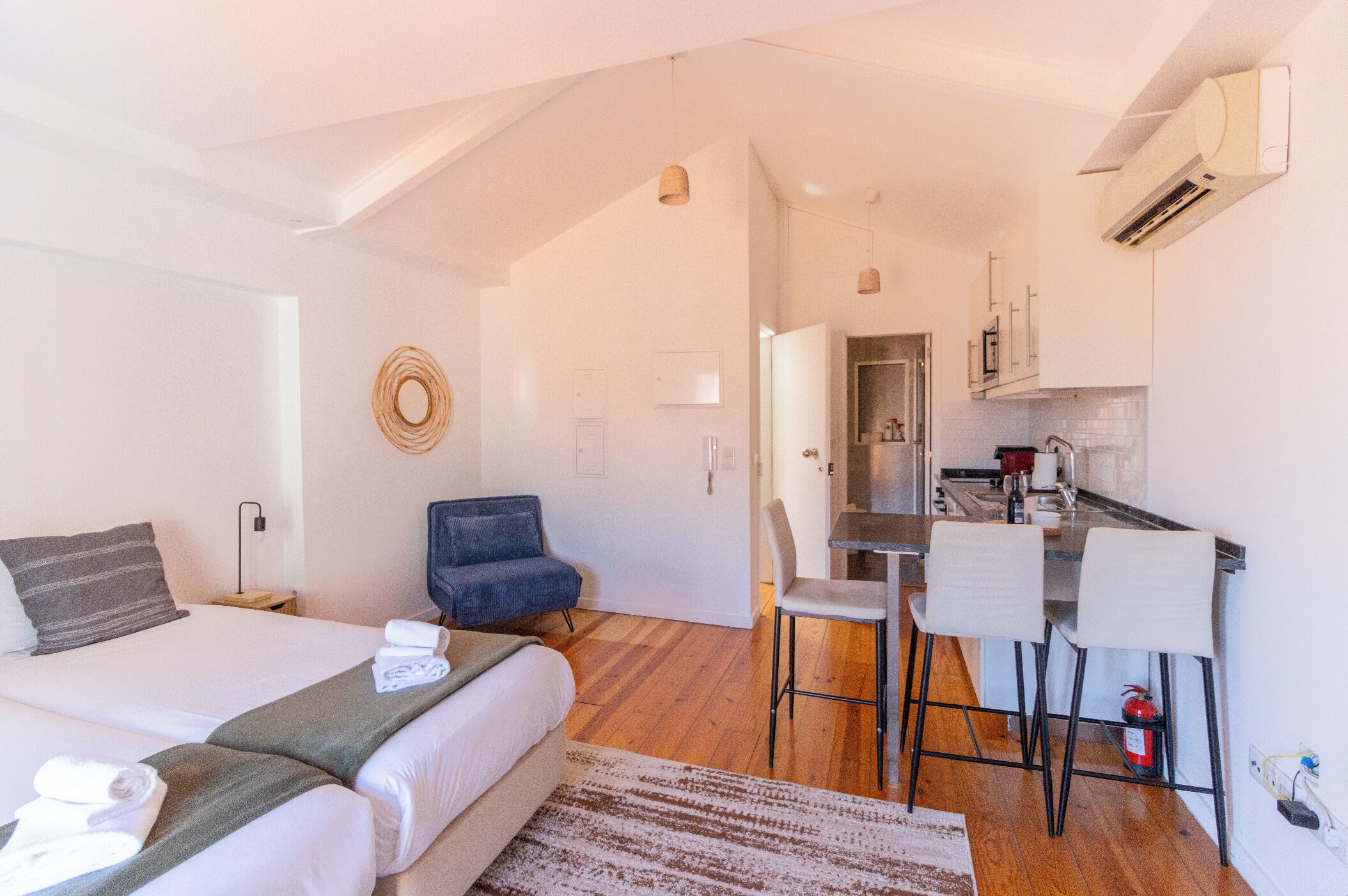 Une chambre d’hôtel moderne équipée d’un lit, d’un bureau et d’une kitchenette.