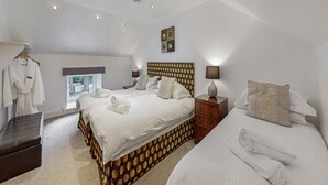 A hotel room with two beds, a wardrobe, a vanity with a mirror, and a window with a view. - 9-bedroom Scottish Retreat (Colintraive)