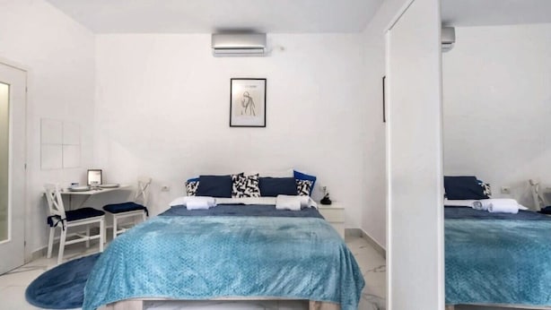 A bedroom with a bed, a desk, and a chair. - Charming Studio in a Historic Bucharest Courtyard (București)