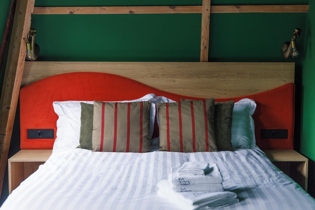A bed with white bedding, multiple pillows, and a wooden headboard.