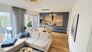 Un salon moderne comprenant un canapé, une table basse et un coin repas avec une table et des chaises.