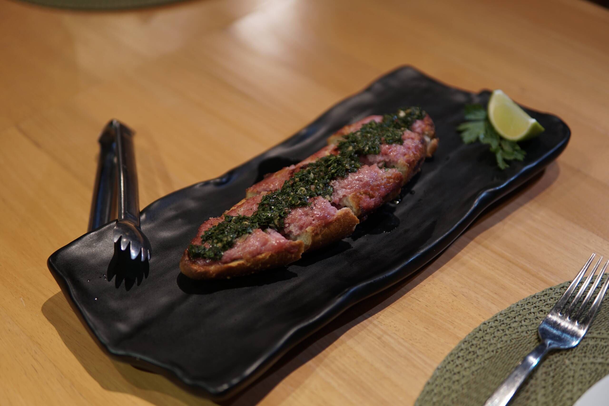 Un plato con comida, un tenedor y un cuchillo sobre una mesa.