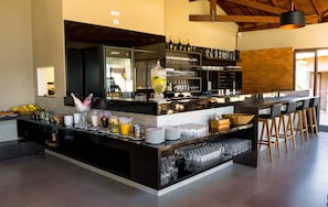 A modern bar area with a wine rack, bar stools, and a variety of glassware.