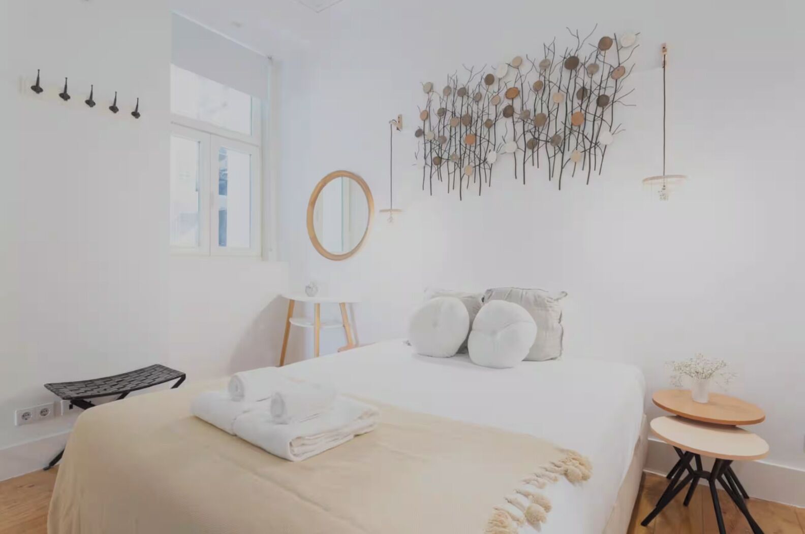 Une chambre à coucher au style minimaliste, avec un lit, une table de chevet et un miroir fixé au mur.