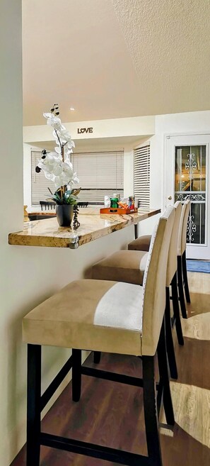 A dining area with a long table, chairs, and a potted plant.