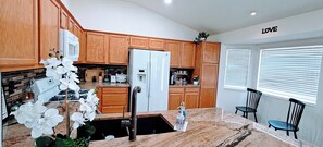 A kitchen with wooden cabinets, a white refrigerator, and a sink.