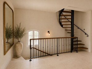 A staircase with a wooden handrail and black balusters, leading to an upper floor. - Luxury Provençal villa recently refurbished to an exceptional standard. (Fayence)