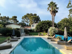 A swimming pool with lounge chairs and a house in the background. - Luxury Provençal villa recently refurbished to an exceptional standard. (Fayence)