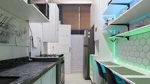 A narrow kitchen with a gas stove, white cabinets, and a green countertop.