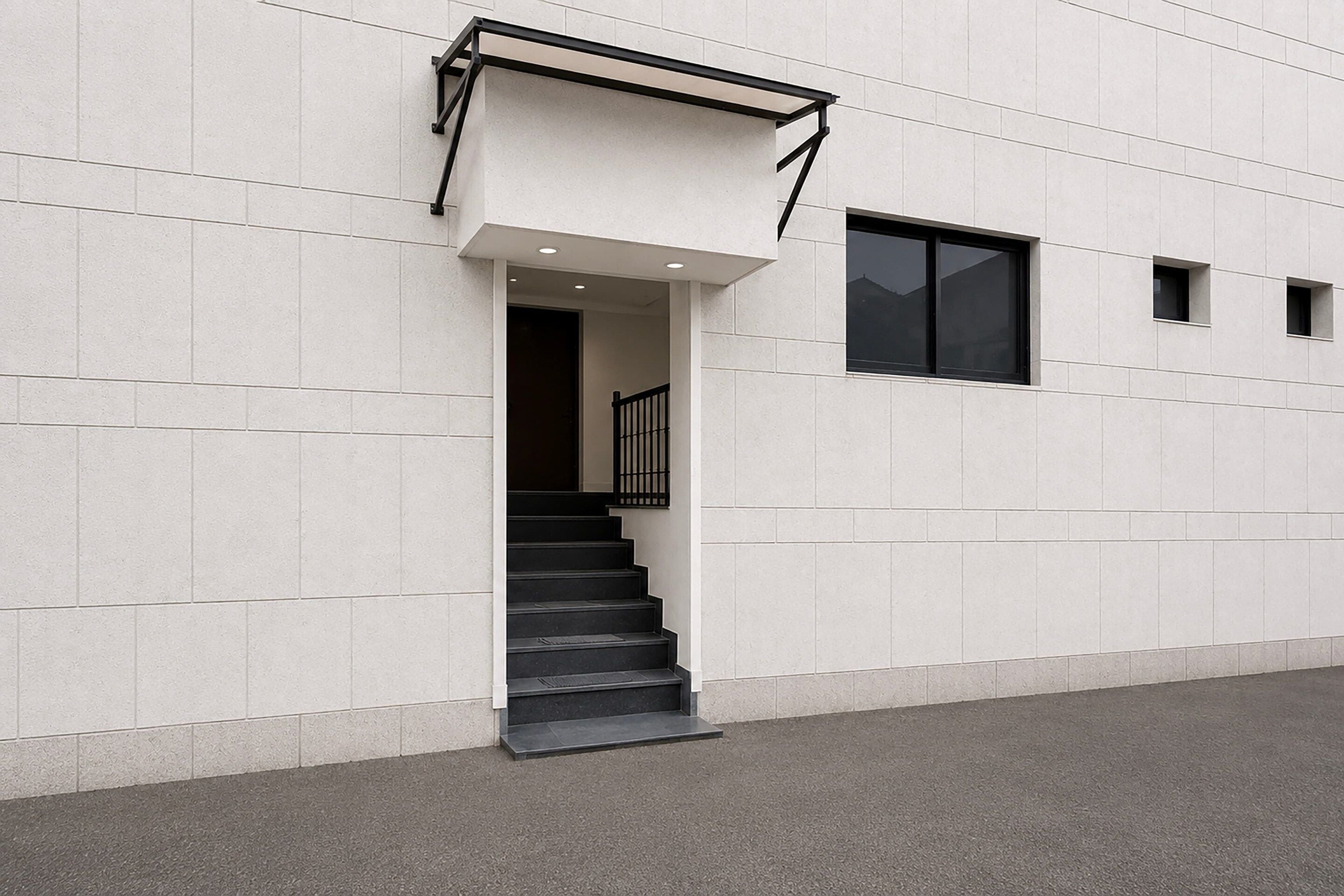 A modern building with a staircase leading to an entrance.