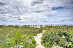 A beach path leading to a sandy area with cacti and vegetation. - Oceanfront Bliss, Top Floor, 2BR, Indoor Pool & Hot Tub, Free Parking, Elevators (North Myrtle Beach)