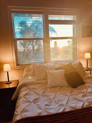 A bedroom with a bed, two bedside lamps, and a window with blinds. - Stunning Superstition Views-Hiking, Golf, Adventure. (Apache Junction)