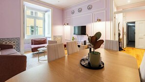 Una sala de estar moderna con una mesa de comedor, sofás y una televisión.