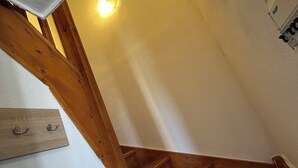 Eine Holztreppe mit einer Wandleuchte.