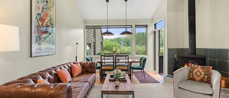 A spacious living room with a leather sofa, a coffee table, and a fireplace.