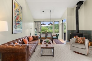 A spacious living room with a leather sofa, a coffee table, and a fireplace.