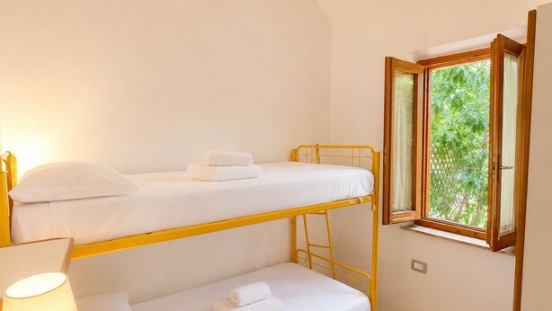 A bunk bed room with a window and a lamp. - Casa Vacanze San Teodoro (San Teodoro)