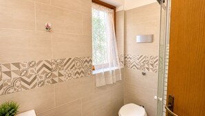 A bathroom with a toilet, a sink, and a shower area. - Casa Vacanze San Teodoro (San Teodoro)