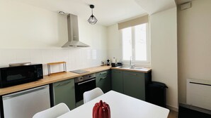 A compact kitchen with a microwave, a kettle, and a sink. - "Sauge de Sarrail" City Center Apartment (Saintes)