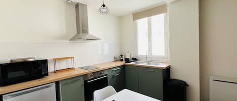 A compact kitchen with a microwave, a kettle, and a sink.